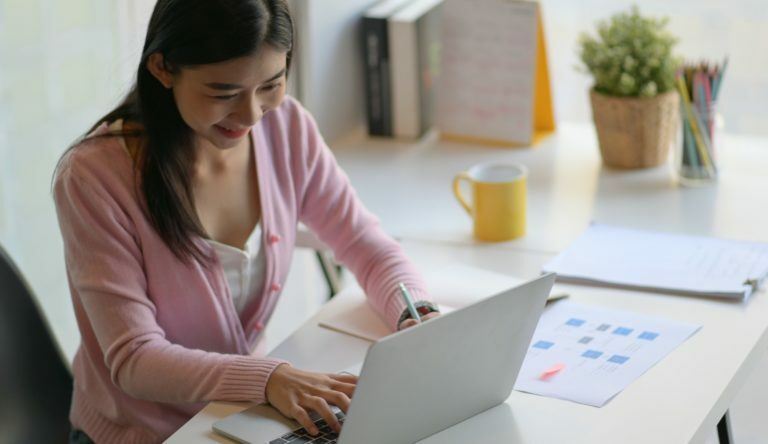 Female student are using laptop to search for information online.