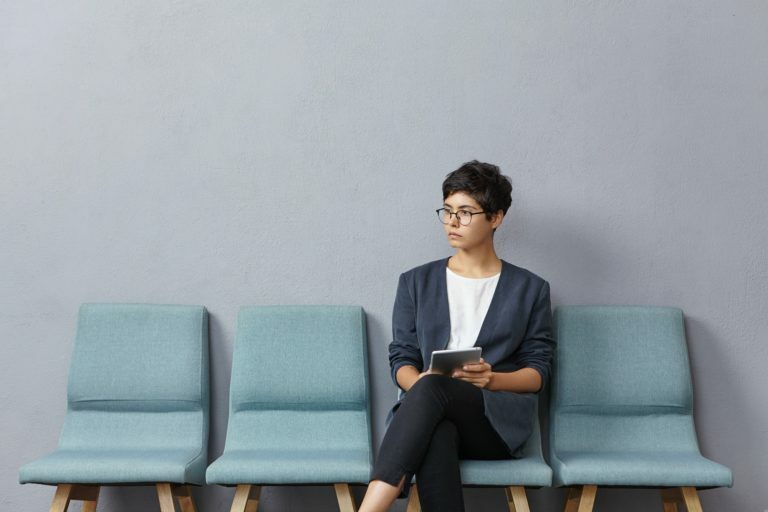 Horizontal portrait of young attractive woman being in anticipation of meeting with potential partne