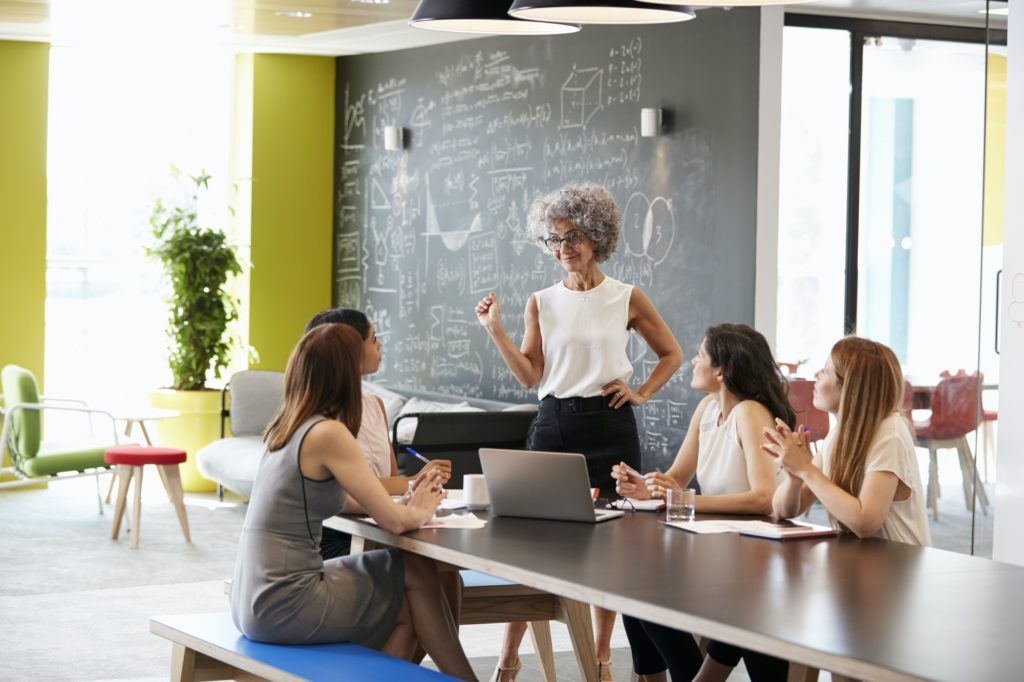 Female boss standing at an informal team meeting
