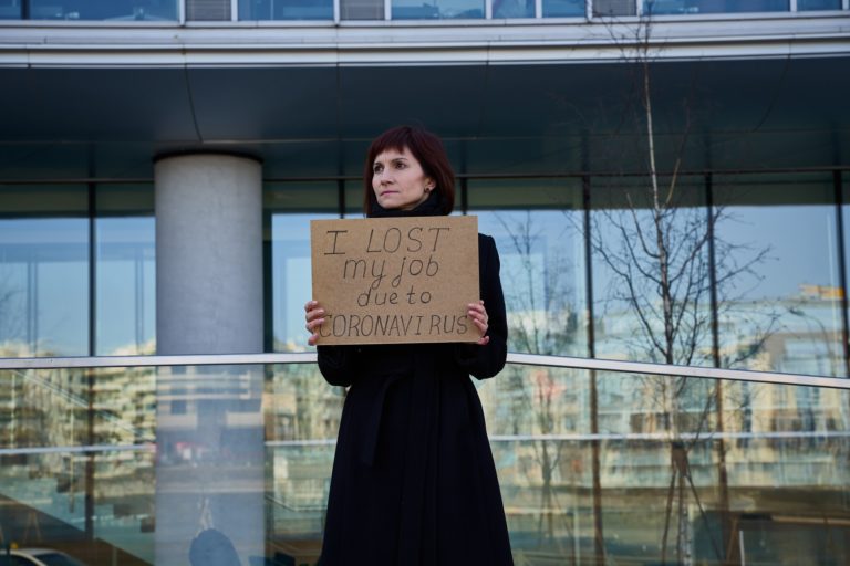 Woman holds sign saying "I lost my job because of coronavirus."