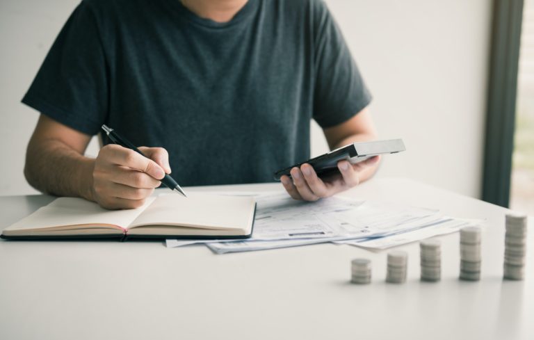 Man use calculators and documents that calculate expenses in the home office.